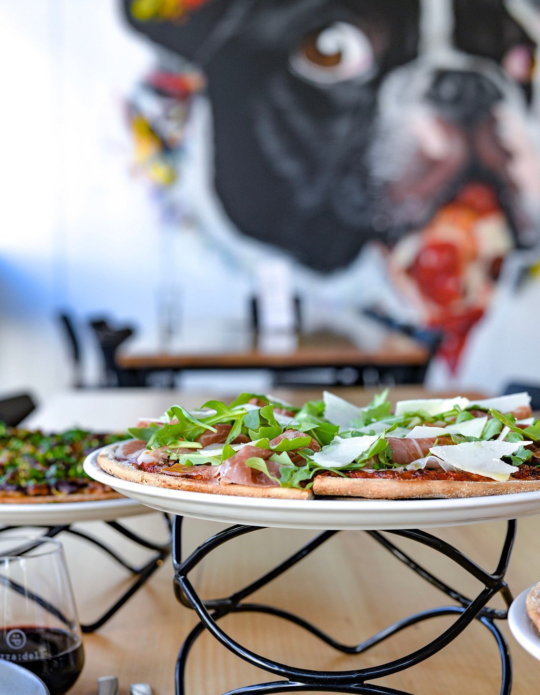 Prosciutto and rocket pizza with the dog mural behind