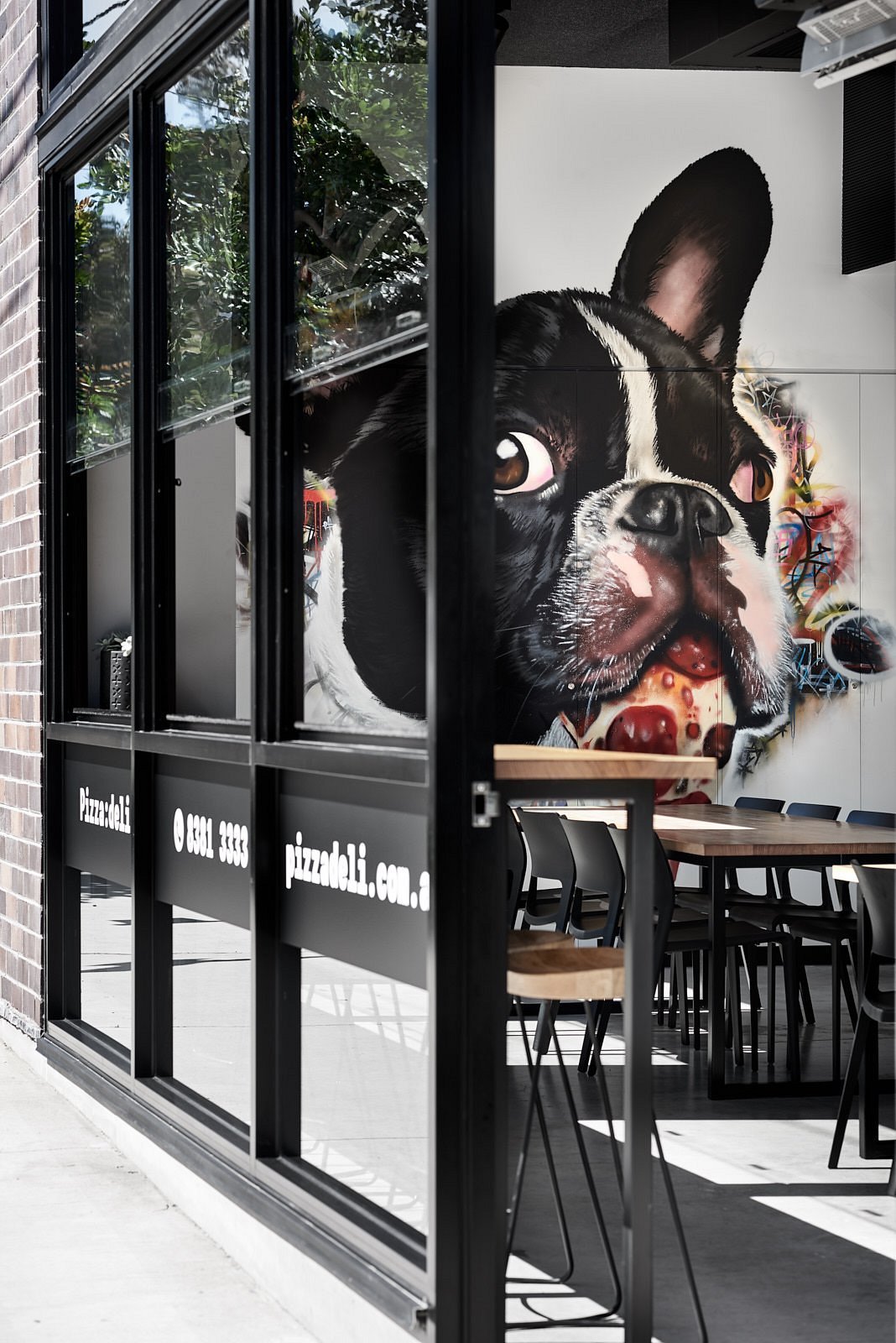 Dog mural seen through the window at Pizza:deli